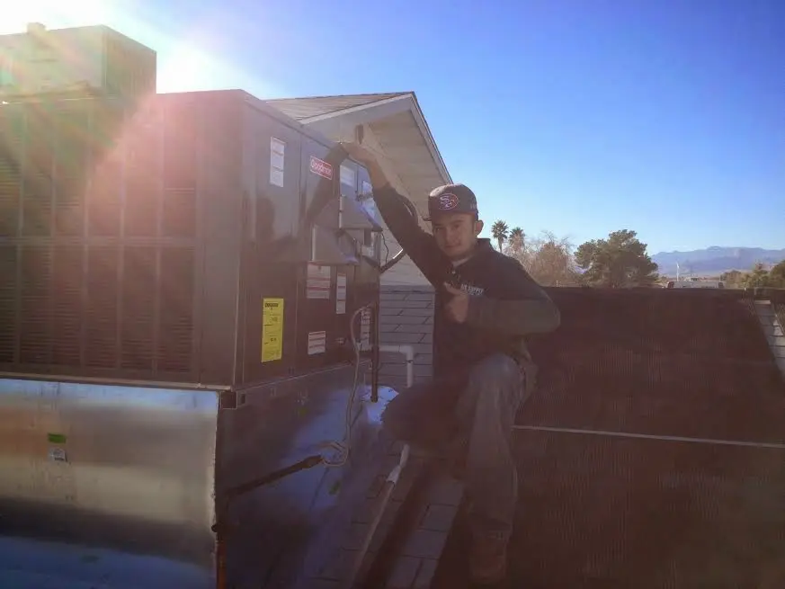 HVAC technician performing Air Duct Repair on a rooftop unit in McMinnville
